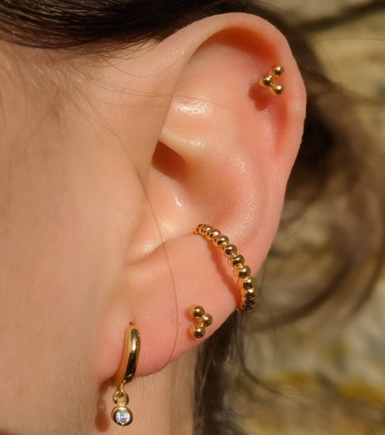 ear full of different earrings including the alice cuff